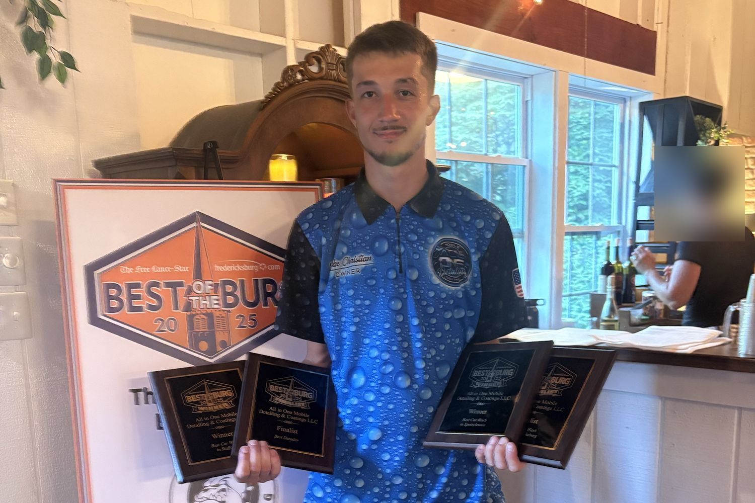 The All-In-One owner holding four Best of the Burg 2025 plaques at the awards event